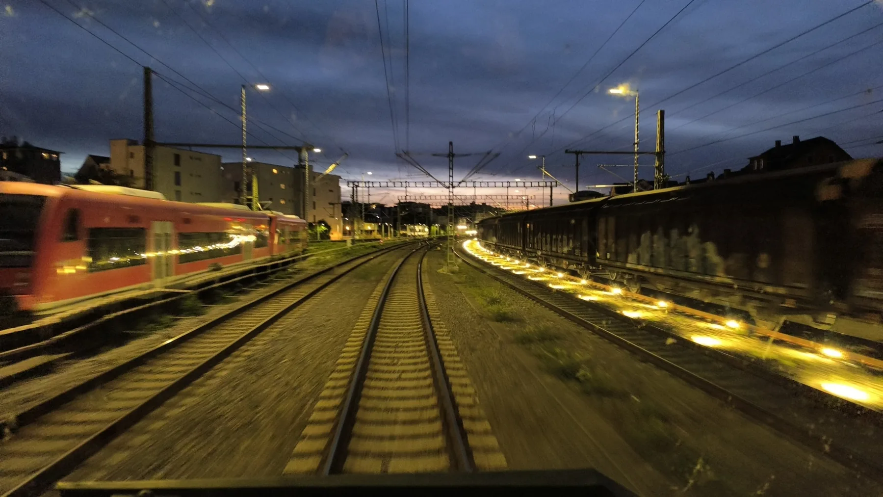 Gleisanlagen mit Zügen in der Abenddämmerung